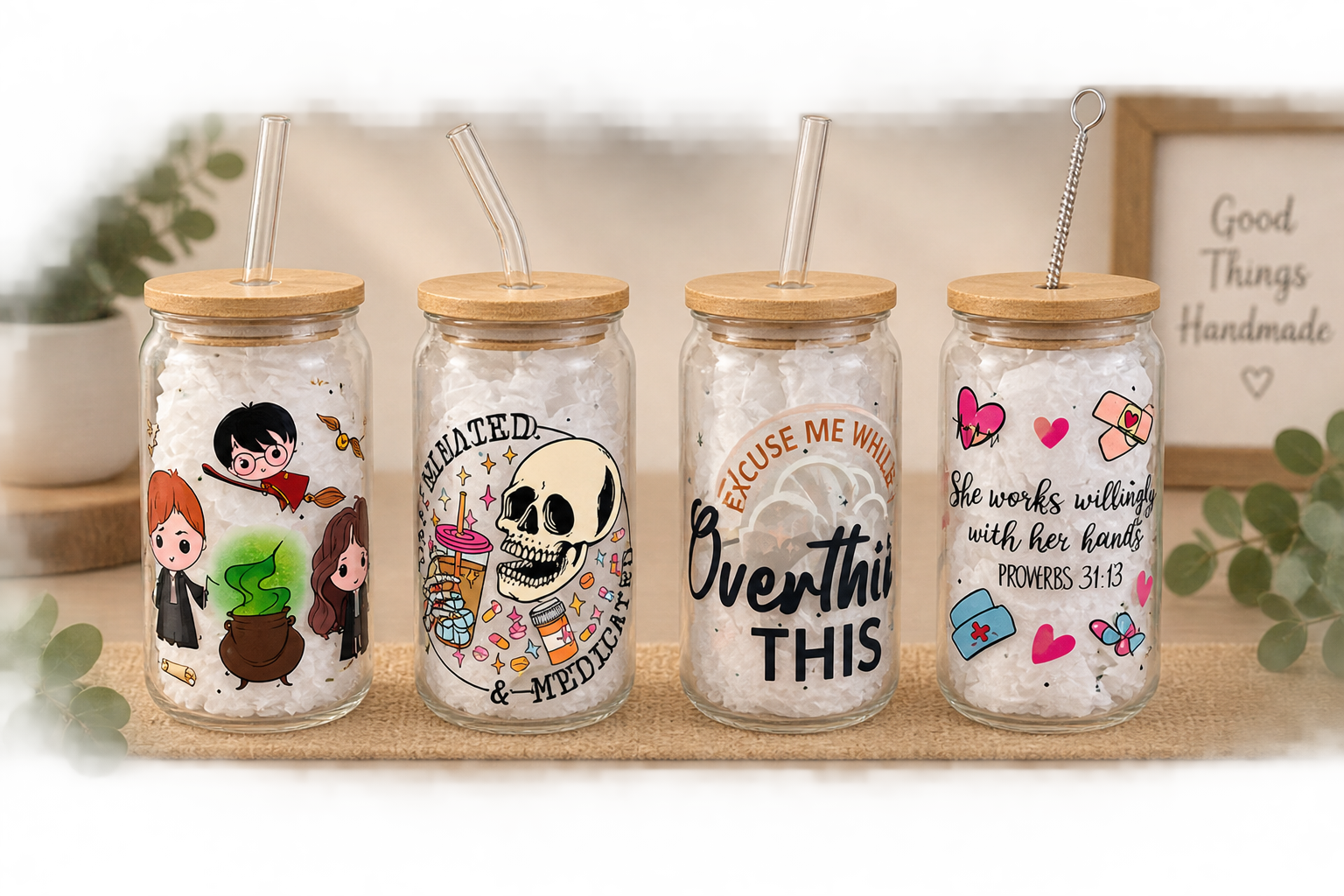 Four handmade glass tumbler cups with bamboo lids and glass straws, each with a different printed design
